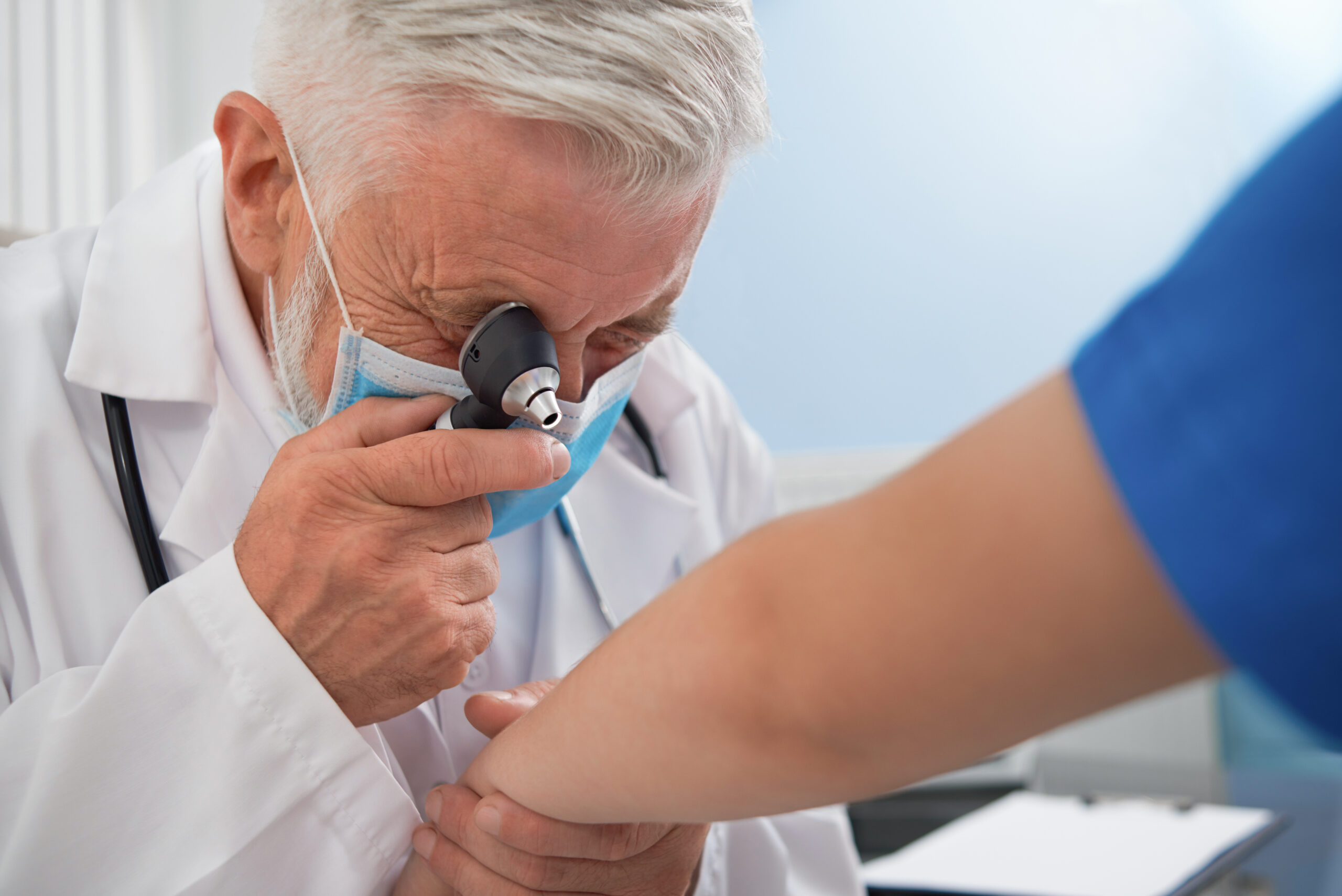 Doctor revisando a paciente que padece una enfermedad cutánea