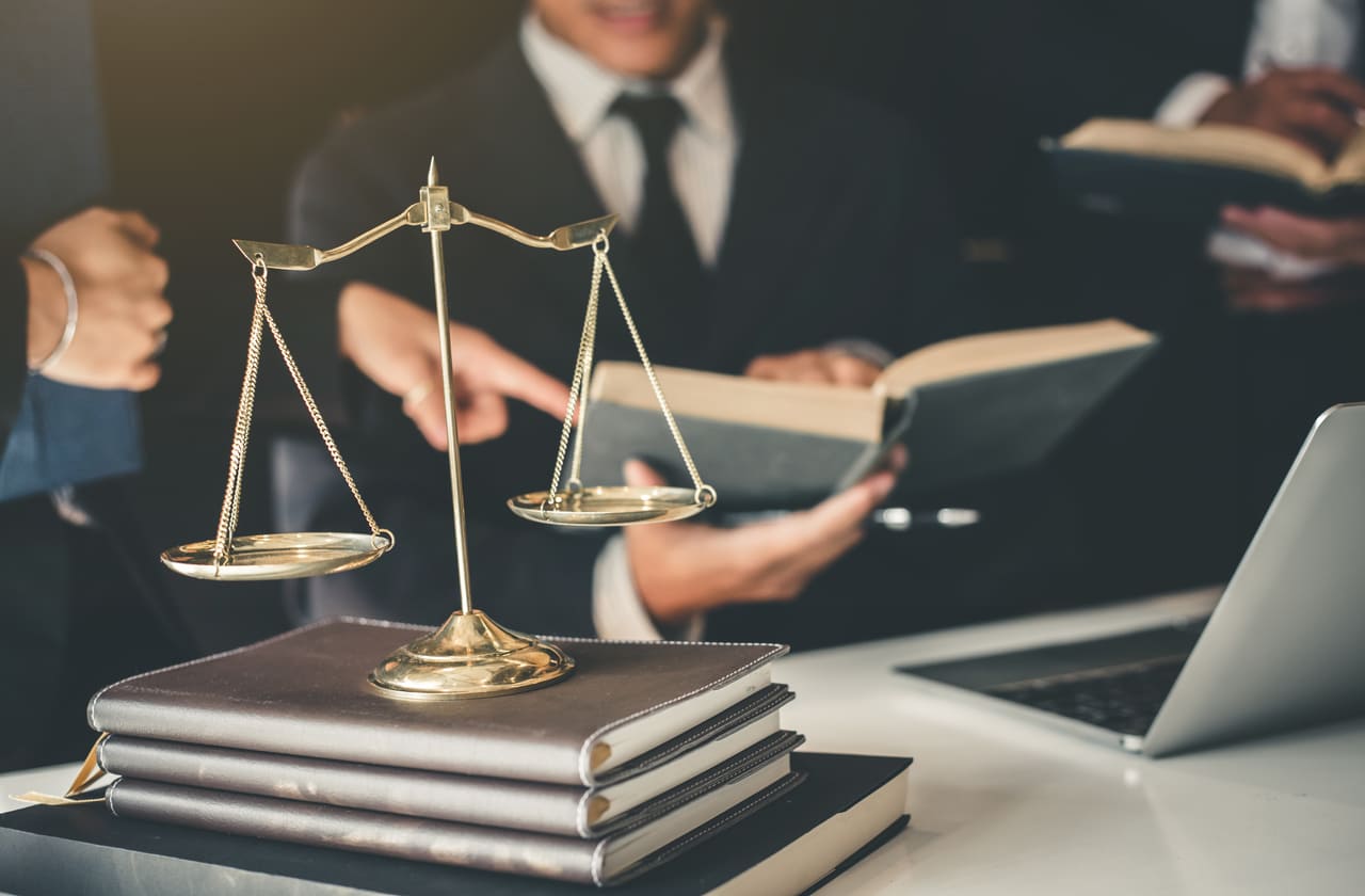 lawyers reading a book with a scale in front of them